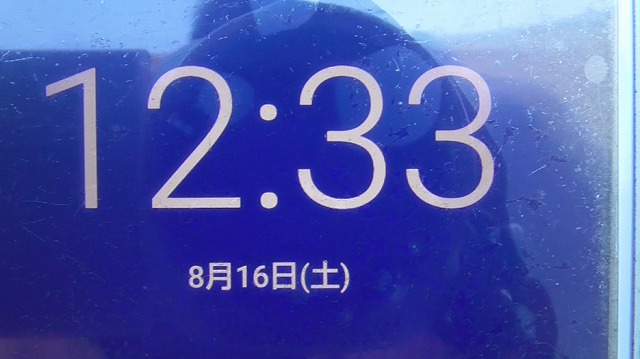 スマホが8月16日の12時33分を表示