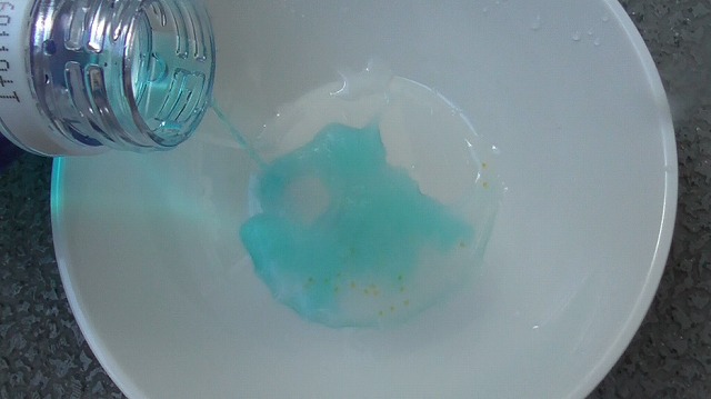 メチレンブルー水溶液を卵の小皿に注ぐ様子