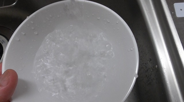 小皿に水道水を注ぐ様子