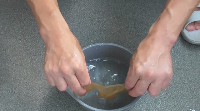 ゾウリムシ培養液が滴った後のコーヒーペーパーを水中でジャブジャブする様子