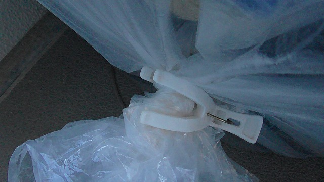 メダカ容器にかぶせたポリ袋の口を洗濯バサミでとめたイメージ